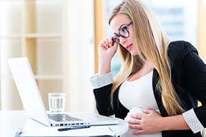 Pregnant woman at work reading wrongful termination laws
