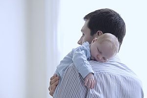 a man holding his newborn son after having spoken to an employment law attorney in case his employer did not allow him to exercise his FMLA rights