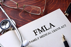 a stethoscope on top of a booklet containing the FMLA guidelines to represent which FMLA benefits requests employers must allow