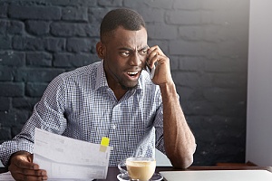 man angry on the phone because of wrongful termination