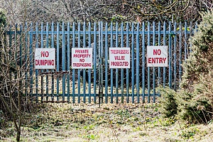 a fence with signs displaying Virginia trespassing laws