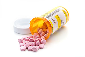 Prescription medication cascading out of orange pharmacy vials