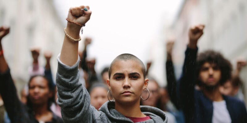 woman protesting on the street with her fist raised in air