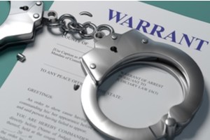 A police warrant and handcuffs