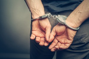 Unlawfully arrested man wearing handcuffs